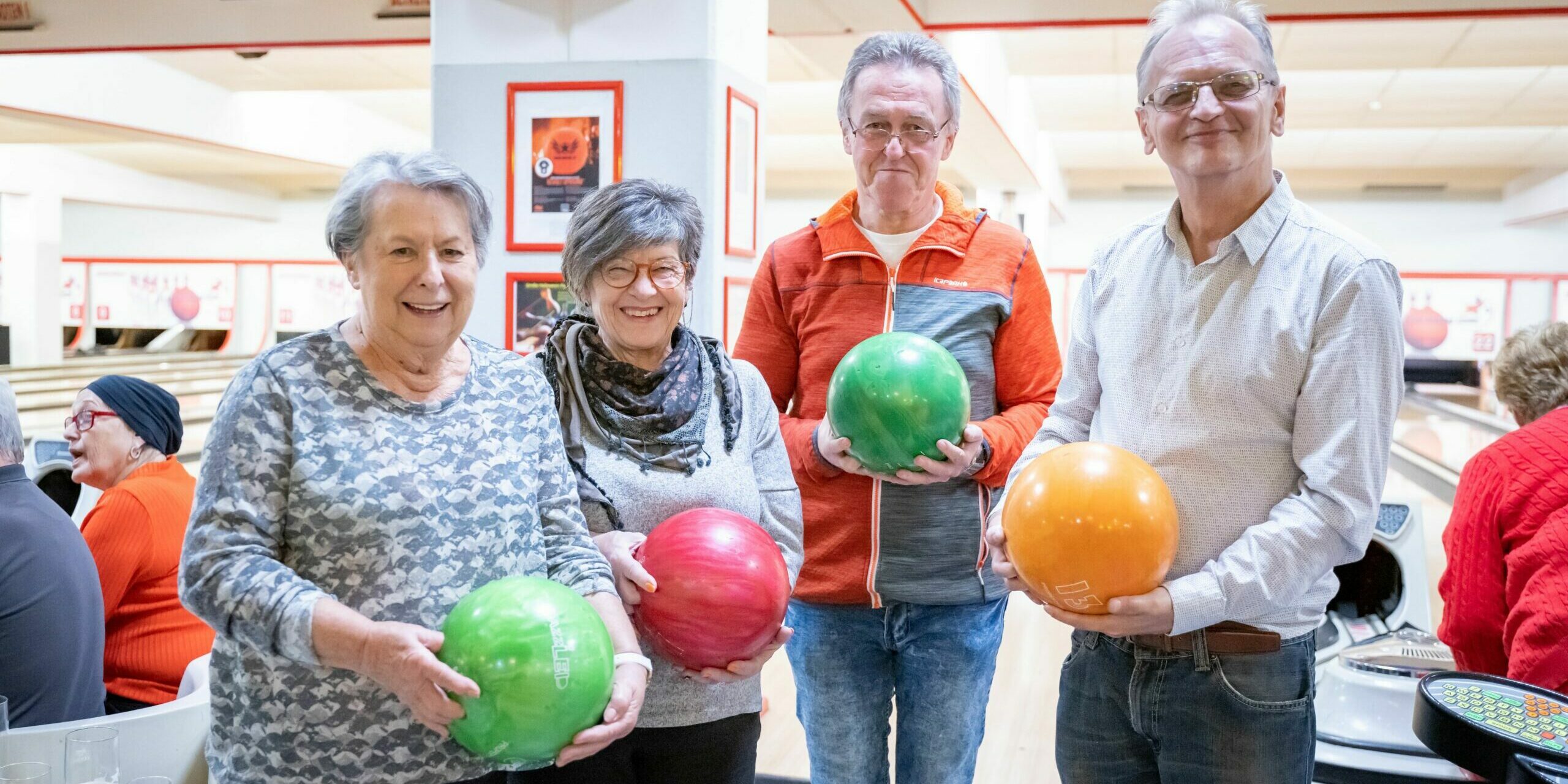 Senior:innen halten Bowlingkugeln in ihren Händen