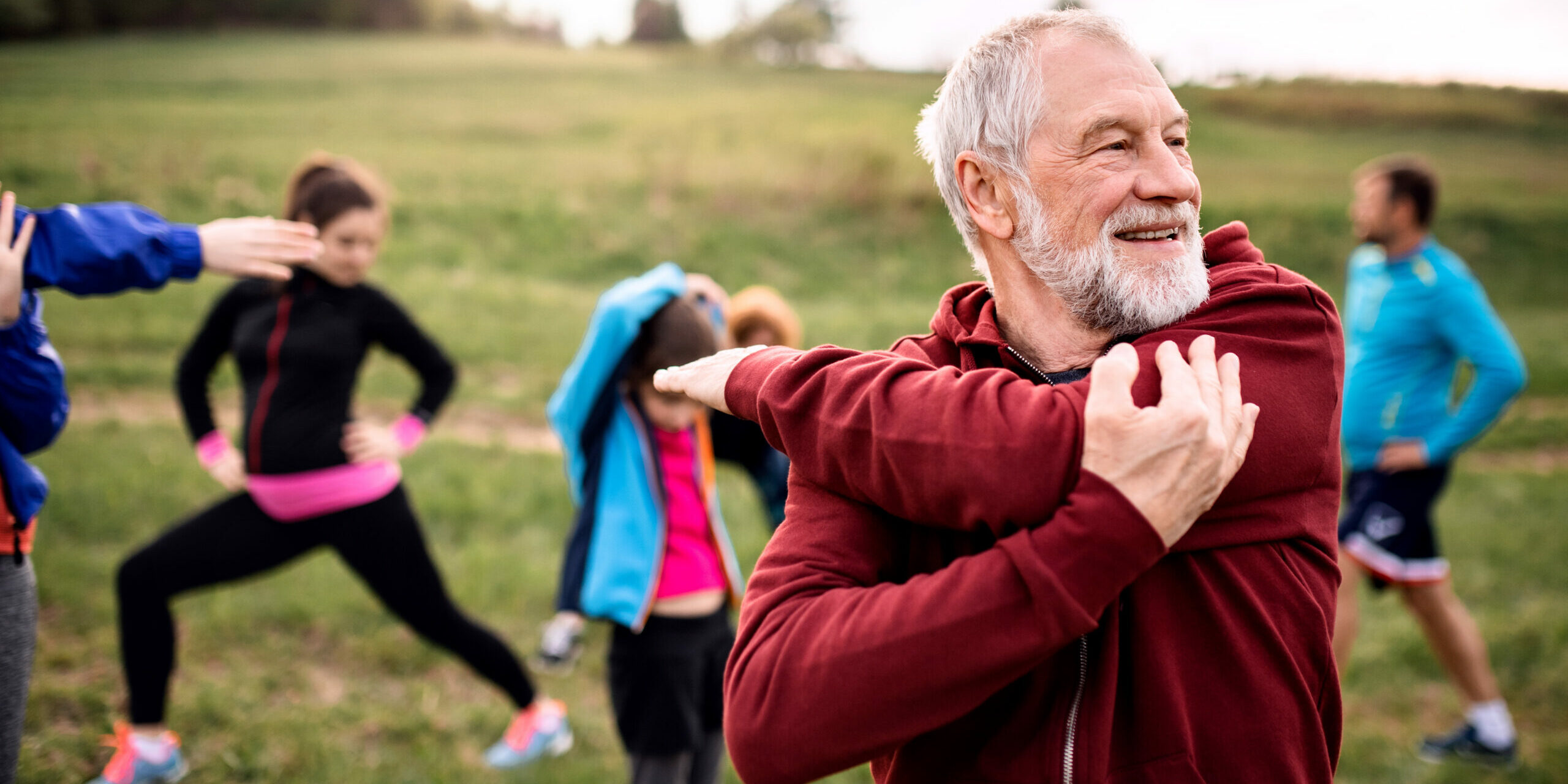 Menschen auf Wiese machen Sport