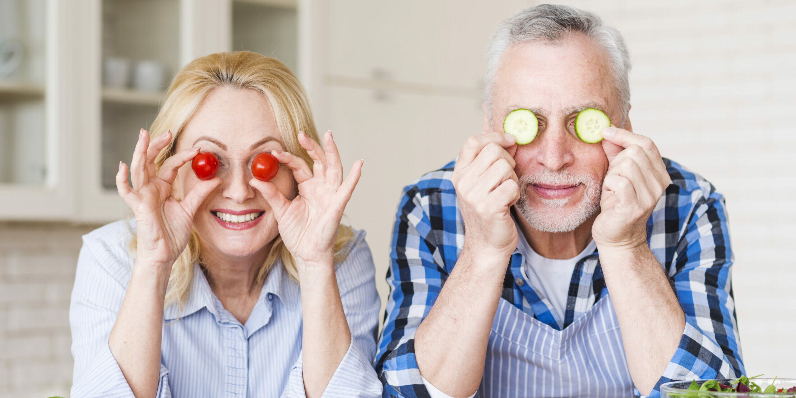 Mann und Frau mit Tomaten und Gurken auf den Augen