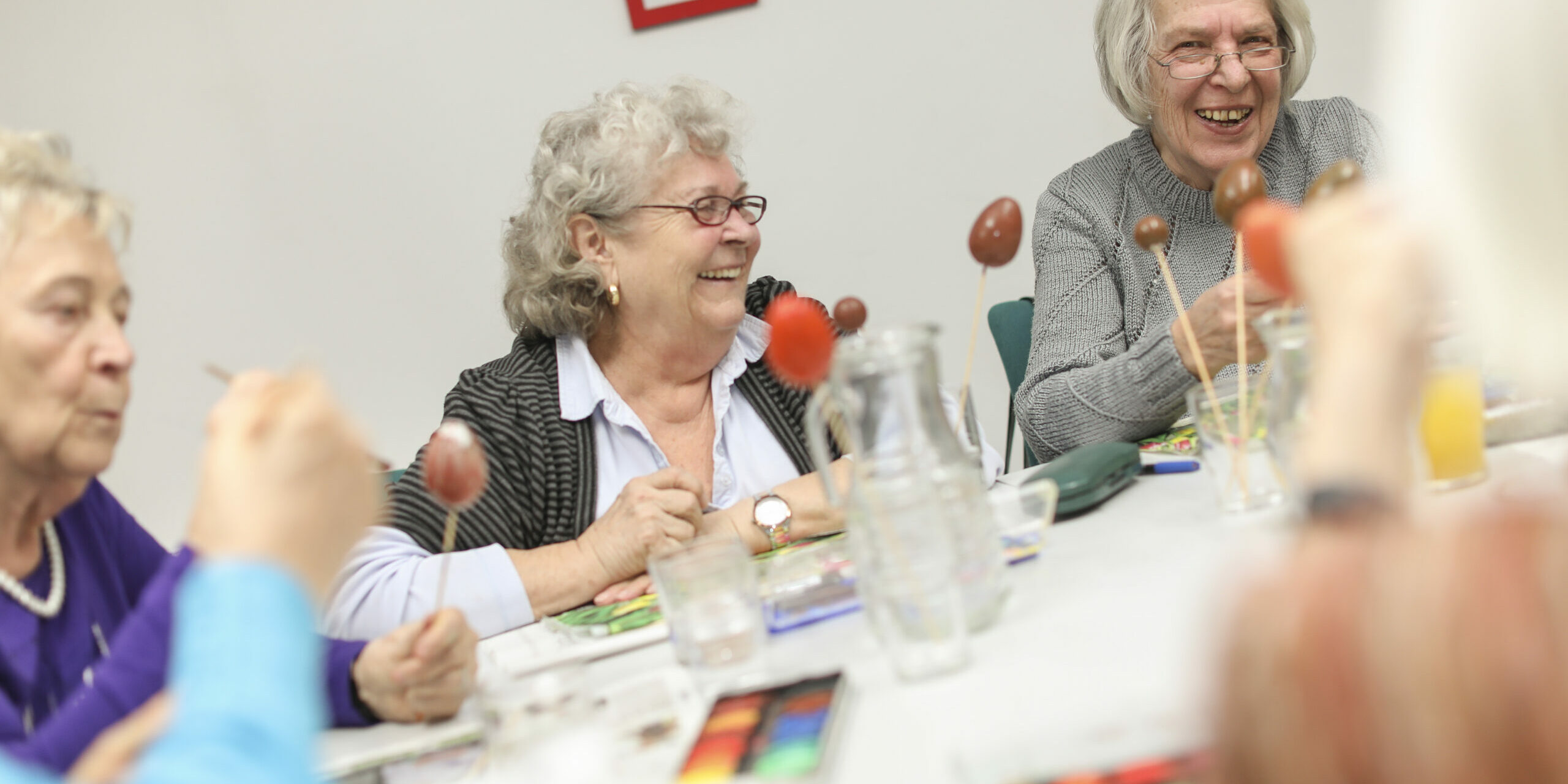 Personen sitzen gemeinsam am Tisch und lachen
