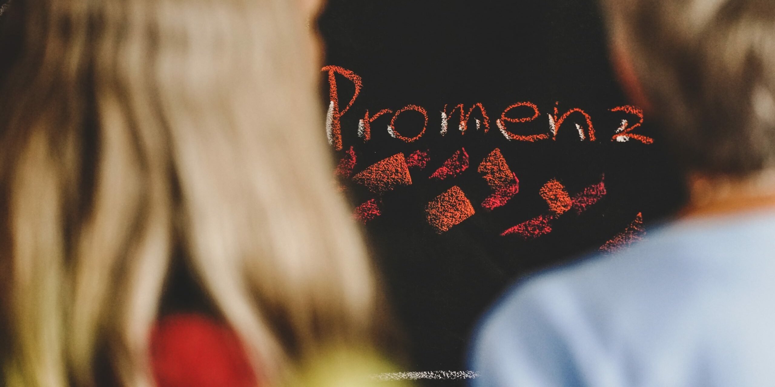 Schriftzug Promenz auf Tafel mit zwei Personen