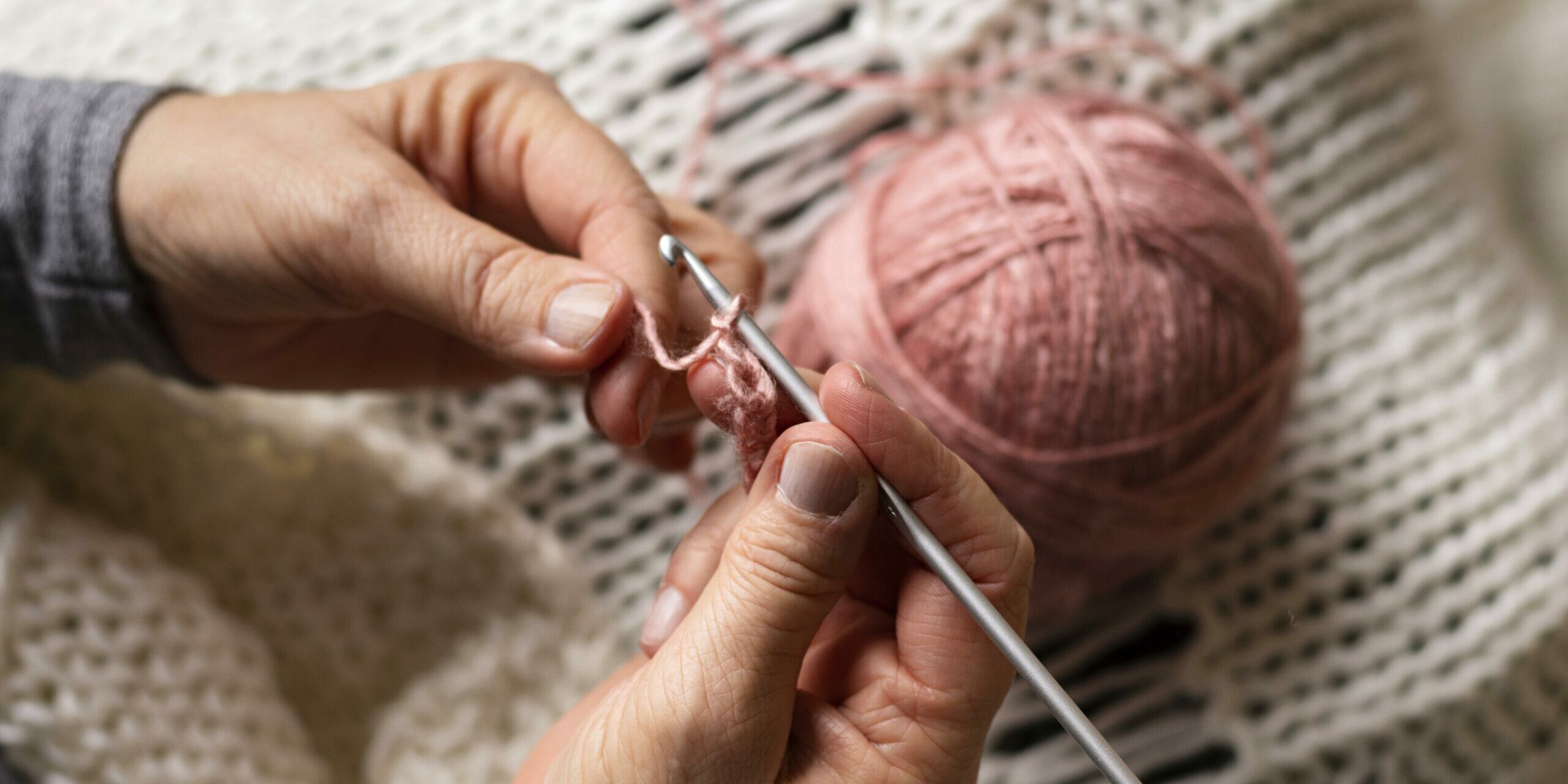 Hände mit Stricknadel